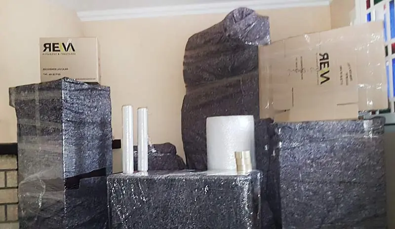 Muebles protegidos con mantas y film junto a cajas de Mudanzas Reva