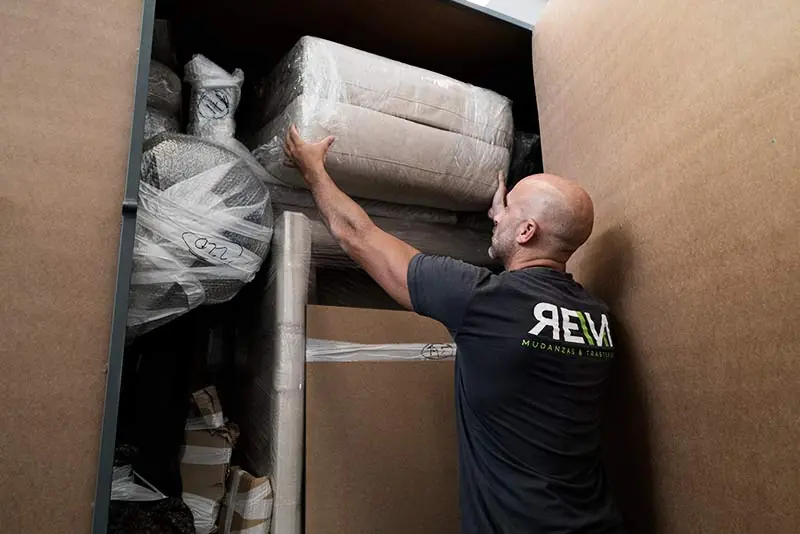 Operario de Mudanzas Reva colocando muebles embalados dentro de un módulo